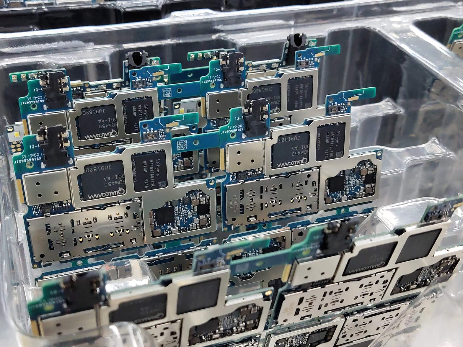 smartphone motherboards placed in box in workshop